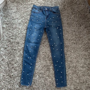 Jeans med pärlor - Fina jeans med pärlor på framsidan. Stretchiga. Frakt ingår.