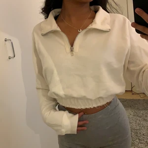 Vit croppad långärmat  - Vit långärmat tröja från Pretty Little Thing med zip framifrån. Storlek S men passar även en Xs. Super snygg men har bara använt den en gång. Tröjan är i bra skick. Jag är 152 cm och passar bra på en som är under 160 cm.