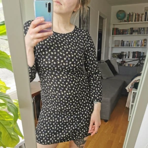 Småblommig klänning - Mörkblå småblommig klänning strl S. Trekvartsärm, dragkedja i ryggen. Mäter 92 cm över bysten, 80 cm i midjan, längd 81 cm. Köpare står för porto 63 kr (spårbart) 