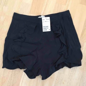  - Marinblå shorts med lappen kvar från H&M. 