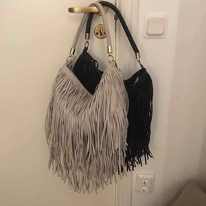  - Två fransväskor från H&M. (40kr/styck) En beige/grå och en svart. Den svartas blixtlås är sönder så går inte att stänga (se bild) men går säkert att laga! Till den beiga tillhör ett långt avtagbart axelband! Köpare står själv för frakt:)