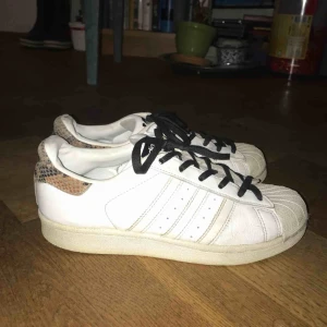  - Adidas superstar sneakers, rena och relativt oslitna. Snygg detalj i ormskinn på hälen av skon! 