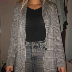  - Grå rutig blazer/kavaj från H&M. Aldrig använd. Storlek 40 men är som en storlek 38. Två fickor och knapp där framme