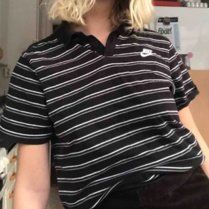  - (Pris inkluderat frakt) en piké tröja från nike. Svart och grå randig.