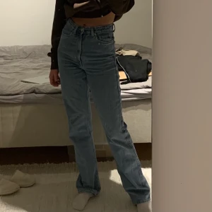 Weekday Rowe jeans strl:25/34 - Högmidjade blåa jeans från weekday i modellen Rowe. Strl:25/34. Jättefint skick förutom några enstaka fläckar på vänster bakben som man kan se på sista bilden. Tror dem kommer ifrån blekning som råkat skvätta.  Fraktkostnaden står köparen för!😊