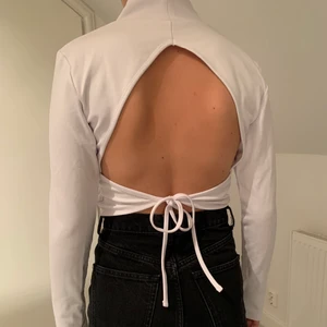 SNYGG TOPP MED ÖPPEN RYGG - En otroligt snygg vit topp med öppen rygg från NAKD. Äääälskar passformen på denna topp och den sitter så sjukt snyggt på. Använd max 1 gång och säljer för 80kr. 