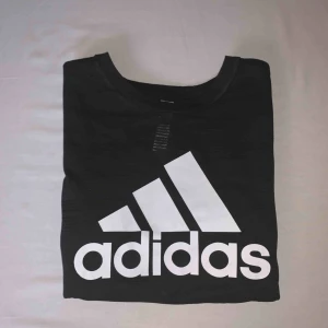  - • Svart Adidaströja med vitt tryck• Aldrig använd• Nyskick•T-shirt• Fler bilder kan skickas vis intresse•Lite ”mesh” aktigt material•Kan användas till vardags men också som träningtröja