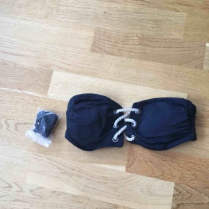  - Bikiniöverdel från hm i bandeaumodell men har även band/snören men kan sätta fast. Knäpps bak och har snygga dekorativa ”rep” där fram. Använd i endast en timme men tyvärr för liten för mig. Storlek 34.   Kolla gärna in mina andra annonser! 
