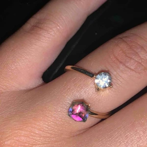  - Cool ring i guldfärg med två stenar i. En silver och en ”regnbåge”. Storleken går att bestämma lite själv då man kan göra avståndet mellan stenarna större eller mindre!