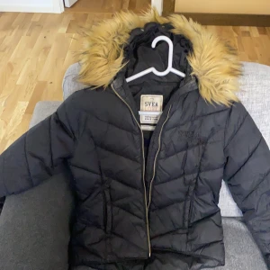 Svea - Svea jacka. Storlek 160. Har fejk päls. Köpt för 800kr. Säljs för 500kr.