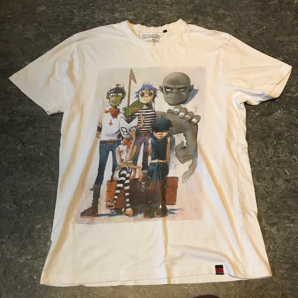 En vit gorillaz band tröja. Storlek L. Kan mötas upp i Stockholm eller posta. Frakt 44kr meddela mig om eventuella frågor:). T-shirts.