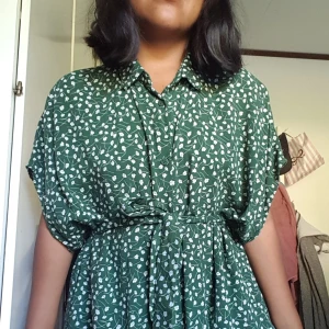 Midi klänning med FICKOR - Fin Klänning från monki, knälång. Kommer med matchande bälte för att knyta i midjan. Mörkgrön jätte mjuk att ha på sig och har fickor. Fint skick används ej.:(