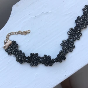 Choker - Choker med glittriga blommor. Aldrig använd. Priset är inkl frakt.