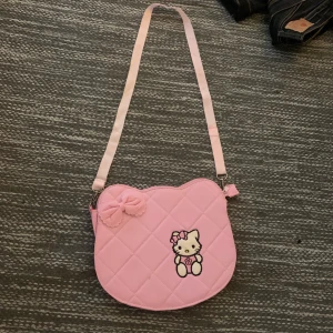 Typ hello kitty väska - Rosa väska man kan ha som antingen handväska eller över kroppen me typ hello kitty på
