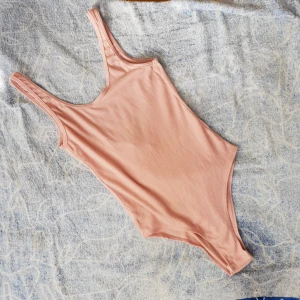  - Supersnygg rubbad body som tyvärr är för liten för mig. Är därför oanvänd. 3 tryckknappar i grenen och djup rygg. Mer ljusrosa än bilden visar. 