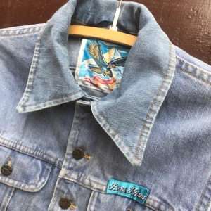  - Vintage jeansjacka från det svenska märket Puss & Kram. 70-tal. Storlek 42 vilket jag uppskattar motsvarar small på denna jacka. Kan hämtas i Uppsala eller skickas spårbart för 58 sek 