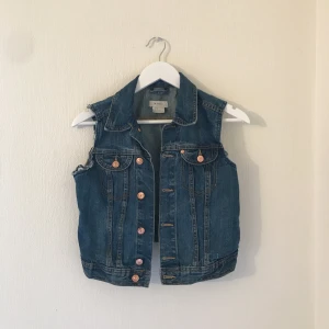  - Jeansväst med slitningar i ärmarna