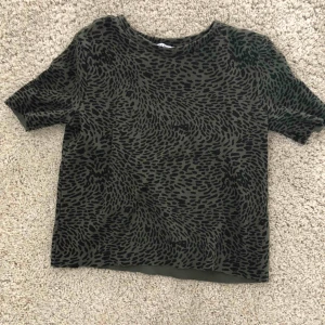  - Snygg grön topp med typ leopard mönster. Trendig och super fin. Budgivning om många är intresserade