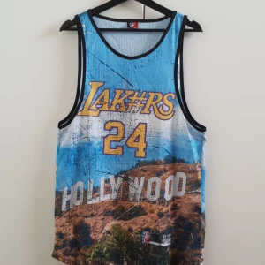 Lakers BLACK MAMBA basketlinne - Ett oversizeat basketlinne i storlek S.  Lakers, nr 24 BLACK MAMBA, fin tribute till den legendariske Koby Bryant som nyligen tragiskt gick bort. 💜💛💜 Jag är en M och den sitter oversizeat på mig. 