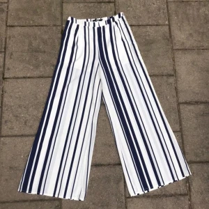 Randiga kostymbyxor - Säljer dessa balla utsvängda kostymbyxorna från bikbok. Fint skick och stängs med en dragkedja i sidan ❤