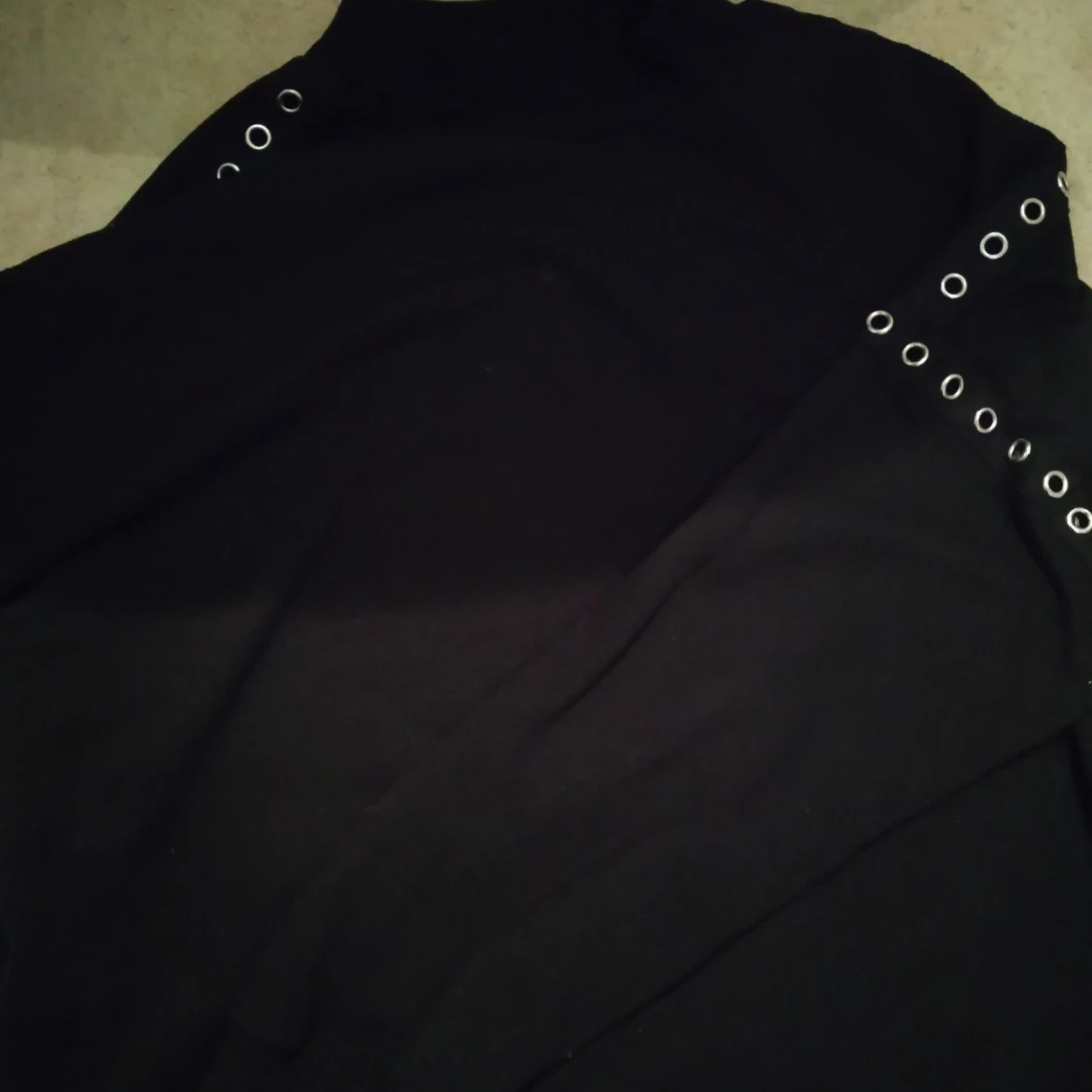 Svart tröja med hål i arméerna som syns  - 90
