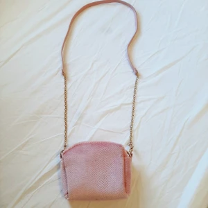 Rosa, guldig väska - Jag säljer en rosa väska som jag fick i present och som har använts några gånger. Jättefint skick! Behöver tyvärr inte den längre, då den endast ligger i hyllan. 