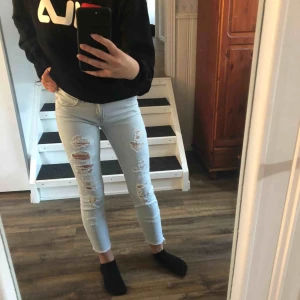  - Ett par snygga ljusblå lågmidjade söndriga jeans med råa kanter vid anklarna.  Köpta i USA på forever21.  Storleken är 32 men passar även en 34.  Endast använda några fåtal gånger, jeansen är som nya. 