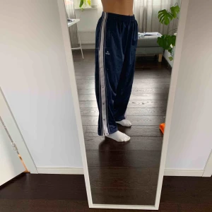  - Haft dessa byxorna nära mitt hjärta i 2-3 år men säljer dem då de blivit för stora för mig. De är ett par mörkblå trackpants med knappar på sidorna som du ser på bilden. Storleken är en M/L och väldigt stretch! Frakt ingår inte
