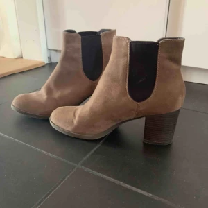  - Ett par lågklackade skor i brun mocka. Bred klack som är bra för hösten.