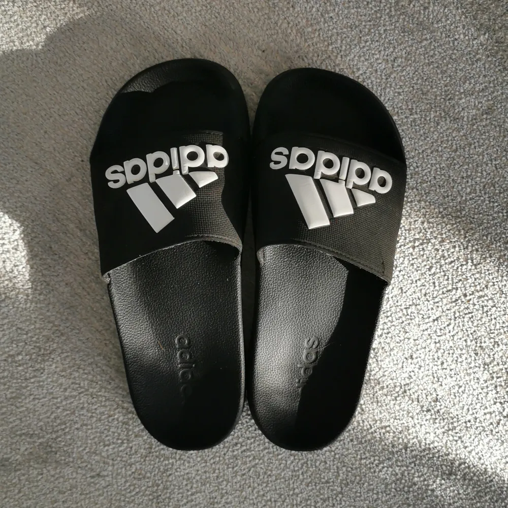 Tofflor från Adidas. Storlek 39. Obs se undersida lol råkade kliva i målarfärg en gång 😅 annars gott skick! . Kengät.