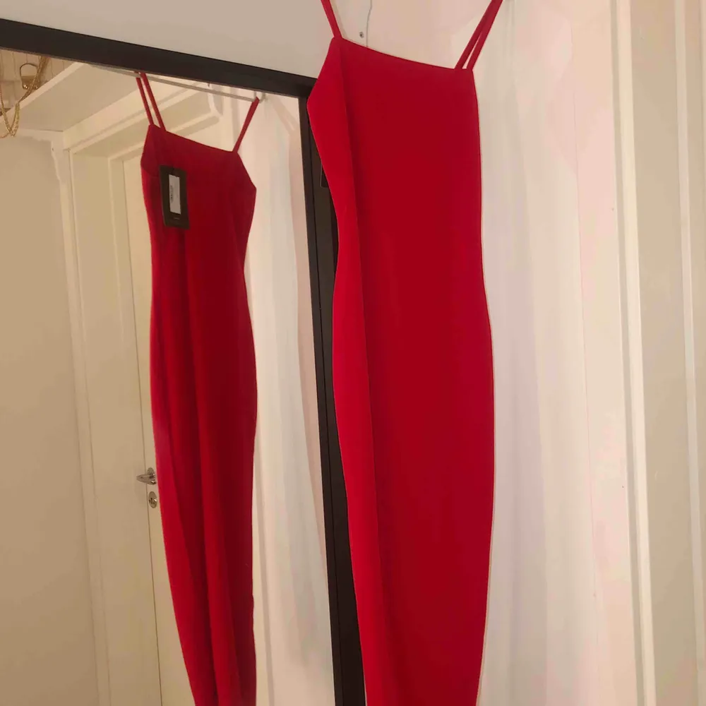 Röd tight klänning med tunna band, sitter väldigt fint och slutar under knäna  . Klänningar.