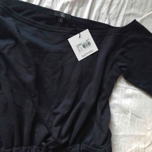 Marinblå helkropps jumpsuit från missguided - En helt ny mörkblå jumpsuit från Missgiuded i mjukismaterial. Har snöre vidmidjan och hål i käna samt off shoulder. Perfekta mys-setet. Om man är lång skulle jag säga att de passar till någon i M annars en liten L. Nypris kanske låg på 350-450kr