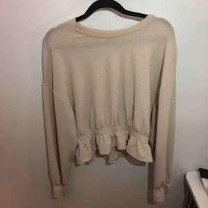  - Ginatricot blus i väldigt fint skick. Den har fina detaljer av volanger vid armar och vid nedre midjan. Storlek: M Färg: beige