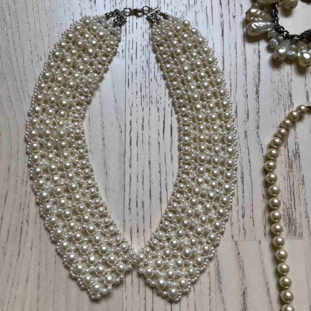 Paketpris för 8 smycken med konstgjorda pärlor: - pärlshalsband formad som en krage - Klassiskt pärlhalsband - Maffigt pärlarmband med stora pärlor - 4 guldmetallfärgade ringar - 1 par silverfärgade örhängen med en glaspärla.. Accessoarer.