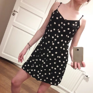  - söt klänning med vita blommor,  justerbara band o knäppning ända ner. 