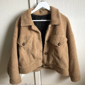 Teddyjacka - Teddyjacka, storlek M, 2 fickor, samt knappar för att stänga jackan. Bra och tjockt material, perfekt till både höst och  vinter. Färg:Ljusbrun/mörk beige.(Aldrig använd)Frakt tillkommer🍂