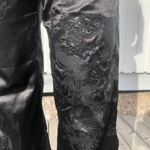 Retro jeans  - Säljer mina super snygga svarta ”jeans” med ett drak mönster på ena benet 