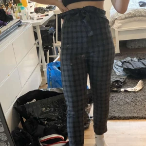 Rutiga papper bag byxor - As snygga grå/svart rutiga papper bags byxor. Helt nya och oanvända då jag tyckte de var alldeles för tajta (är vanligtvis en 38 i byxor och tror att de därför är lite små i storleken). "bältet" kommer med. Frakten är inte inräknat i priset:) 