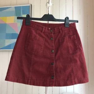 Röd jeanskjol från Monki  - Röd jeanskjol från monki med knappar hela vägen ner, två fickor på framsidan. Storlek 38! Frakt tillkommer❤️