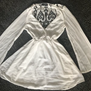 Klänning  - Vit fin sommarklänning med långa ärmar, lång v-ringning men har sytt ett par stygn för mer täckning, fint mönster i ryggen. Ha i åtanke att den är väldigt gammal. Säljer då den inte riktigt är min stil längre🤍