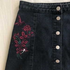 Svart kjol med broderi - Svart kjol med broderier på sidorna. Frakt tillkommer.