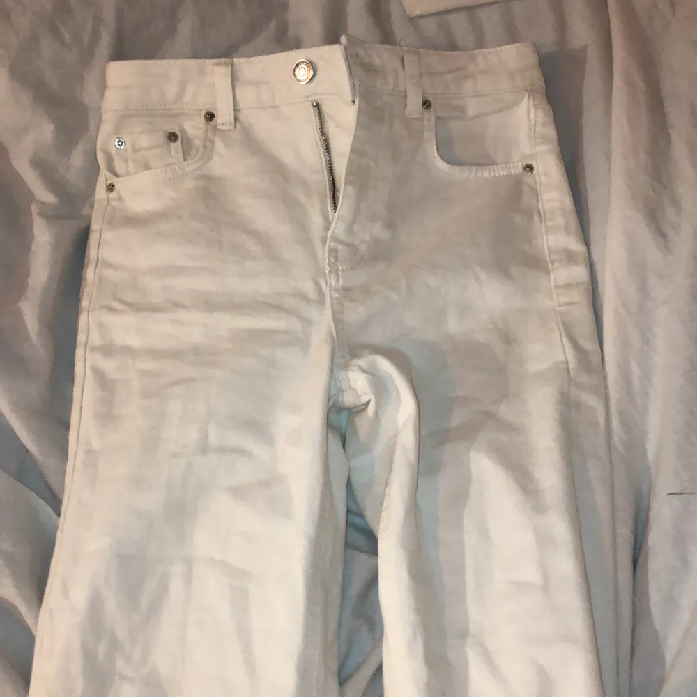 Ett par vita byxor med silvriga knappar. Slitningar längst ner på byxorna, sitter tajt vid höften men blir mer straight längre ner :) har använt typ 3 gånger . Jeans & Byxor.