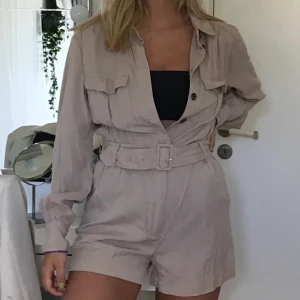 Jumpsuit - Beige jumpsuit ser lite mindre beige ut på bilden. Står storlek 42 på lappen men passar mig som är small då den kan justeras i midjan. Står inte för postens slarv, köparen står för frakt och pris kan diskuteras.
