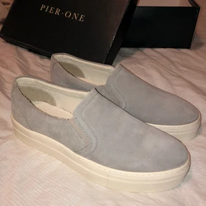 Pier One grey slip ons strl 40 - Oanvända stilrena ljusgrå slip ons från Pier One. Anledningen till att de är oanvända är för att det inte är min storlek⚡️ Storlek: 40 Nypris: 400 kr Köparen står för frakt!