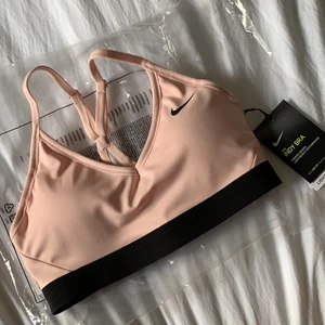 Nike träningsbh - Super fin sport-bh från Nike helt ny!!  Jätte snygg ljusrosa färg. Storleken är en en men är väldigt liten. Sälj pga liten storlek och hade inte kvar returpappet nypris 300 