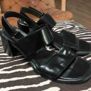  - Fina svarta sandaletter med tjock klack. I svart läder och lack, gjorda i Italien. Strl. 39  Köpta secondhand på Emmaus. Då jag redan har ett par liknande tänker jag att någon annan kan få mer användning för dem! Tillägg för frakt eller mötas upp
