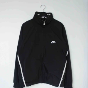  - Säljer en vintage svart Nike trackjacket/windbreaker! Den har en ihopfällbar luva och en insida i mesh!  Size: Medium Cond: 8/10 (gott skick)
