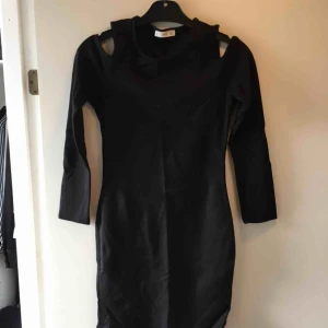  - Den lilla svarta med öppen axel. Långärmad. 