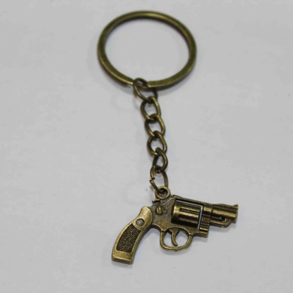 Sjukt cool nyckelring med pistol som hänge!! . Accessoarer.