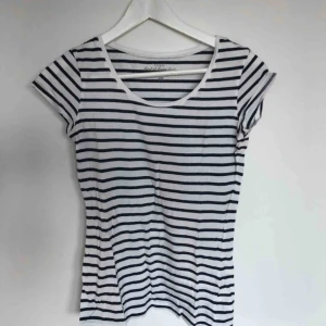  - En vit- och blårandig t-shirt från H&M (L.O.G.G), aldrig använd. Storlek S.